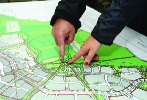 Two hands pointing at the country park on an illustrative masterplan for the northern part of Manydown